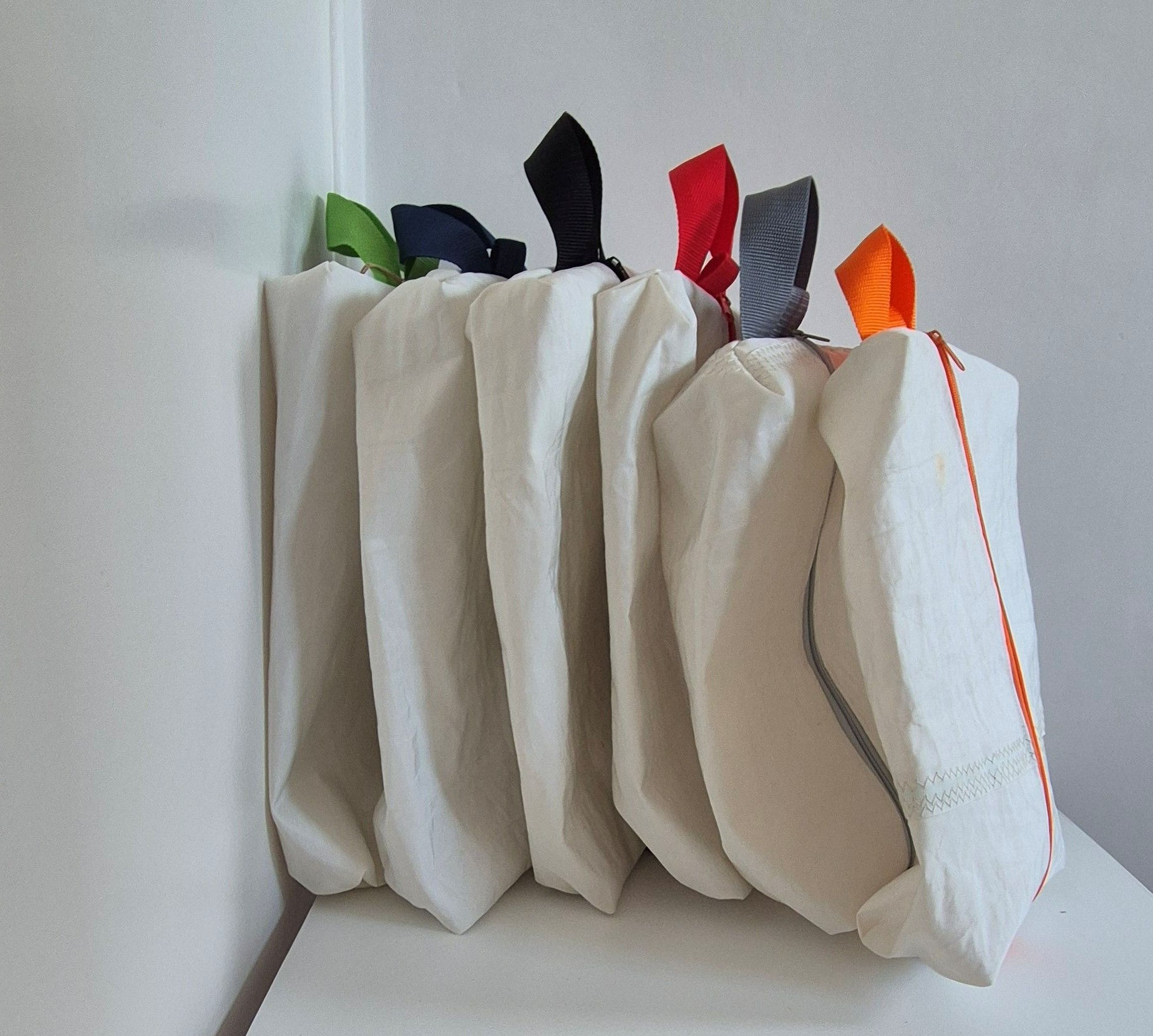 White sail bags with different coloured handles