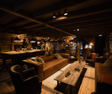 Gezellige lounge met banken, tafels en mensen aan de bar