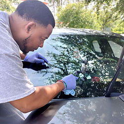 Mobile technician in Gainesville FL performing professional windshield chip repair on driver's side glass.