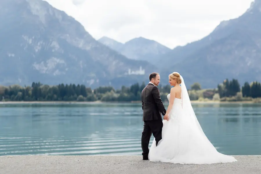 Brautpaar Hand in Hand am See vor den Allgäuer Bergen