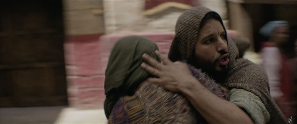 Simon the Zealot shields a woman as they hurry through a street