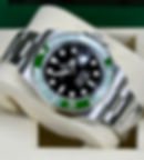 Rolex Submariner Date dive watch featuring a black dial, green bezel, and stainless steel Oyster bracelet, presented in its original box.