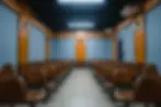 Auditório espaçoso no Colégio Unimor, com assentos marrons e palco bem iluminado, pronto para performances e eventos escolares.