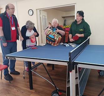 A group of people enjoying a game of table tennis