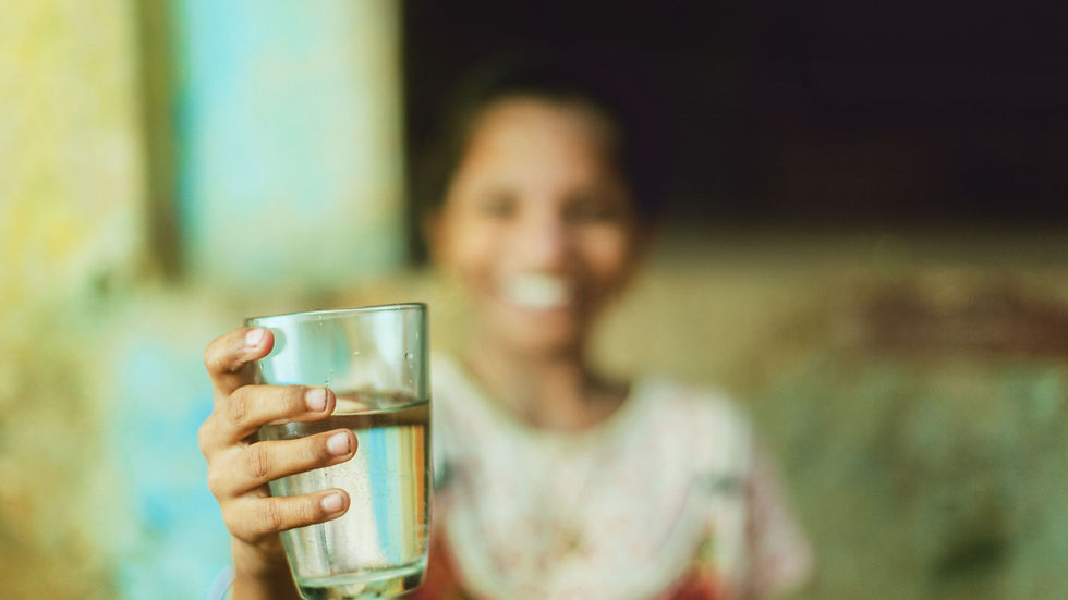 Indian woman holding a glass of clean drinking water