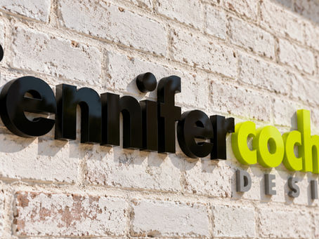 black grey lime green dimensional lettering signage on whitewashed brick wall