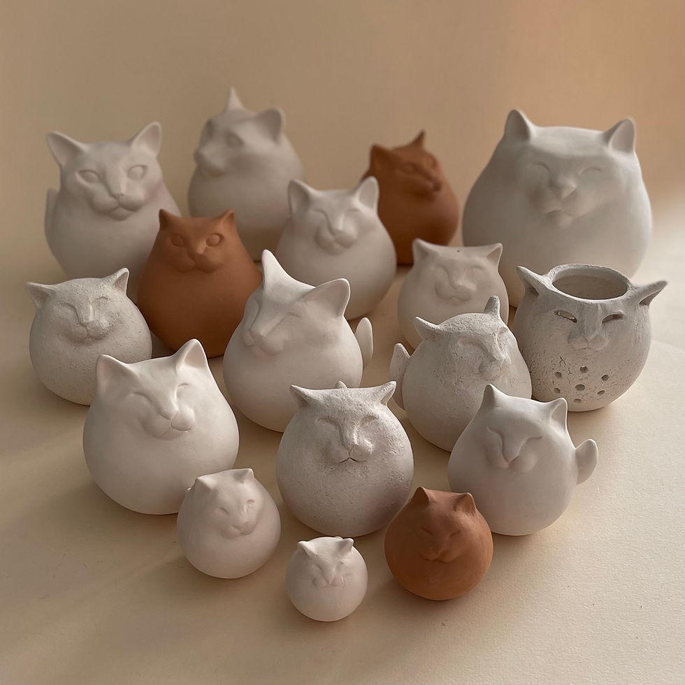 Delle sculture grezze di gatti di terracotta