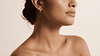Close-up of woman's glowing jawline, neck, and bare shoulder.