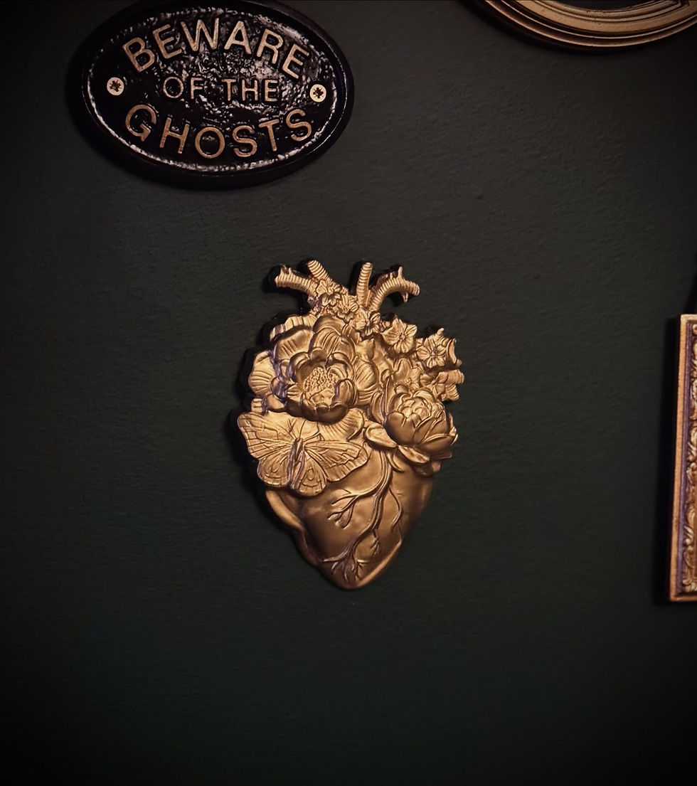 Gold gothic sacred heart wall hanging displayed against dark green gallery wall