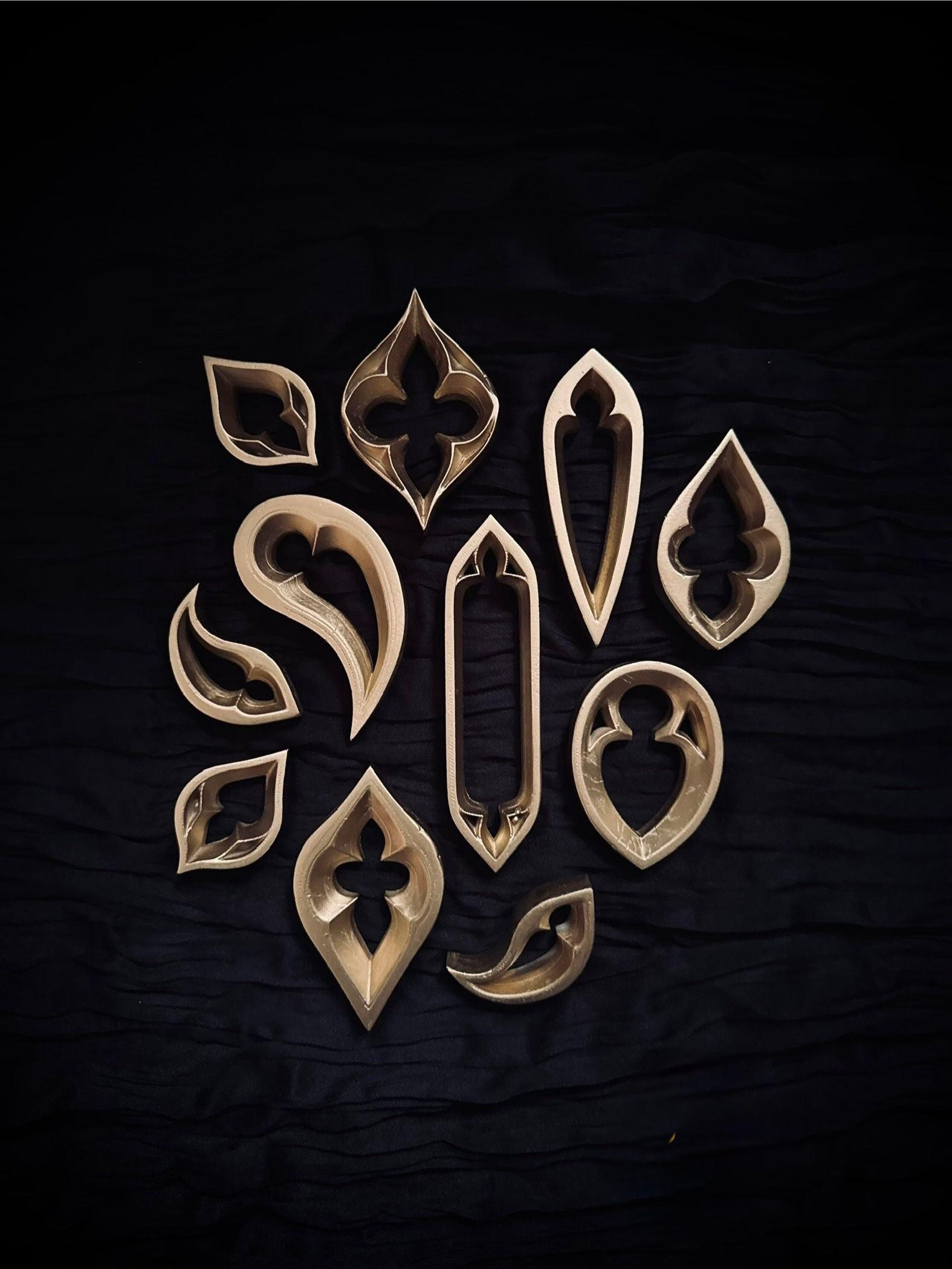 Set of gothic lancet wall fragments arranged together in gold against a dark textured backdrop