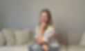 Manuela Adcock sitting on a beige couch smiling