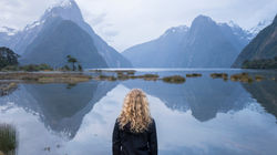 New Zealand Trip Planner | GeoLuxe | woman looking at lake and snowy mountains