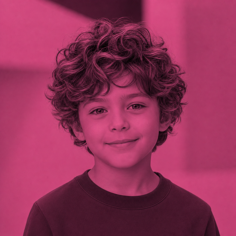 Ein lächelnder Junge mit lockigem Haar vor rosa Hintergrund