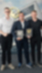 Vier Männer mit Auszeichnungen bei einem Firmenevent.