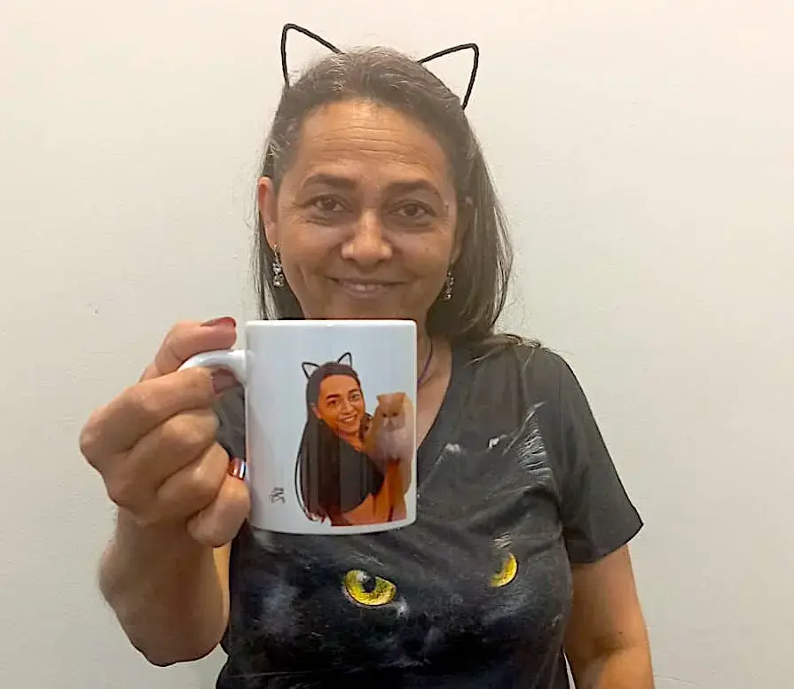 Convidada exibindo lembrança exclusiva, caneca com caricatura digital SouzaArte