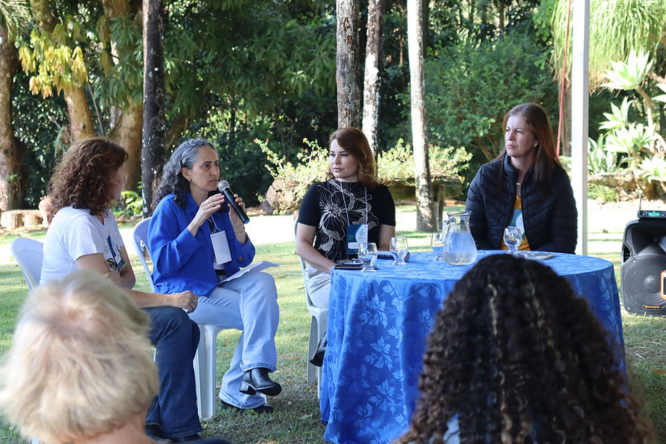 Mulheres participam de painel de diálogo, sentadas à mesa com microfone, discutindo protagonismo feminino e sustentabilidade no Dia de Campo do Cerrado das Águas.