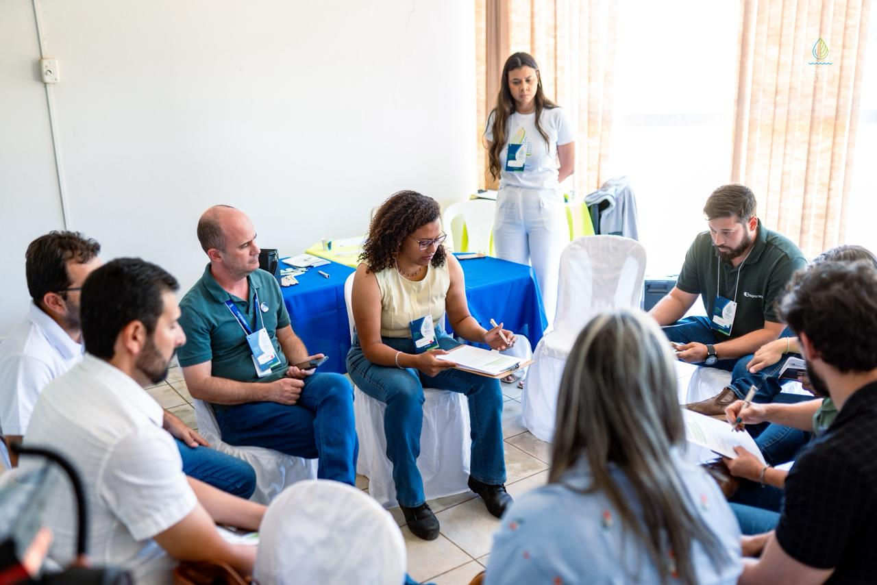 Grupo de produtores e técnicos em roda de conversa tomando notas durante a oficina em Patrocínio (MG).