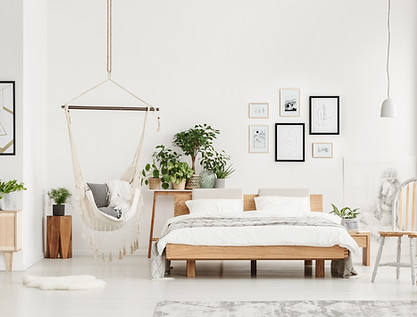A clean and tidy bedroom with white walls and a white comforter