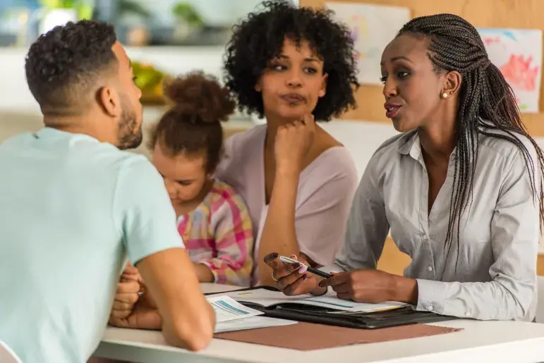 An educator having a session with parents and their child