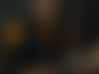 A woman pouring over documents in a castle like room with candles burning late