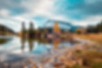 Scenic view of Mount Rundle with snow capped reflecting in Cascade Ponds and fallen leaves