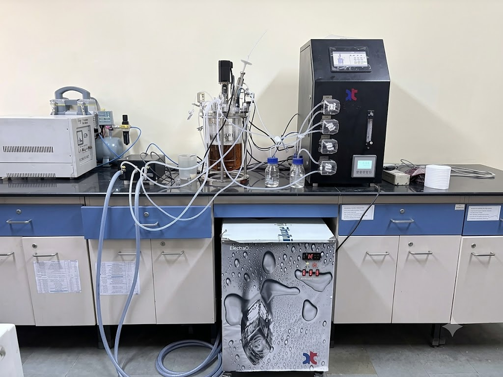Benchtop bioreactor and bioprocess monitoring equipment set up on a laboratory workbench.