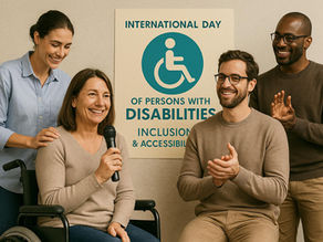 A group of people attend an event on inclusion: a woman in a wheelchair holds a microphone and smiles as she speaks, flanked by others listening and applauding. In the background, a poster dedicated to the International Day of Persons with Disabilities is visible.