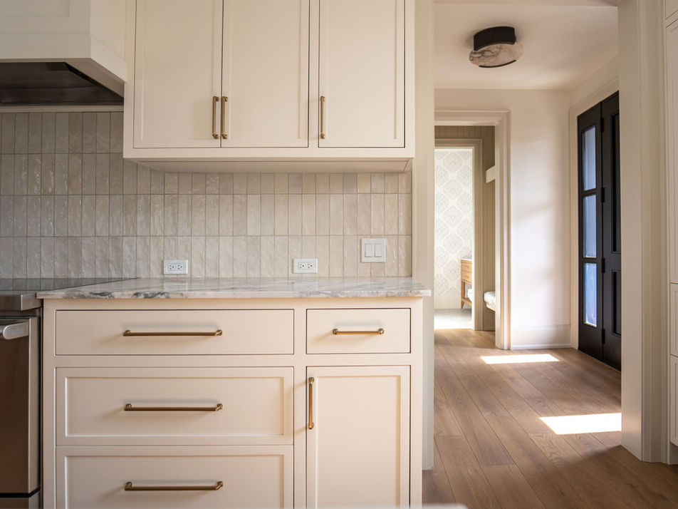 White Cabinets and White Tile Backsplash and Quartz Countertop in Kitchen
