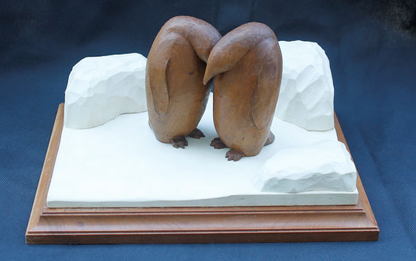 Wood carving of emperor penguins