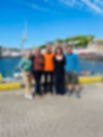 Oban Holiday Lets team smiling in front of the Oban dock