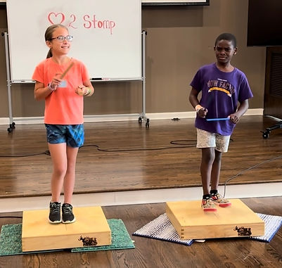 Young students learning to keep rhythm using hands and feet
