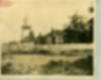 House with shutters and water tower above a cistern house.