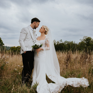 wedding portrait of bride and groom kissing in countryside field at Swallows Oast, East Sussex