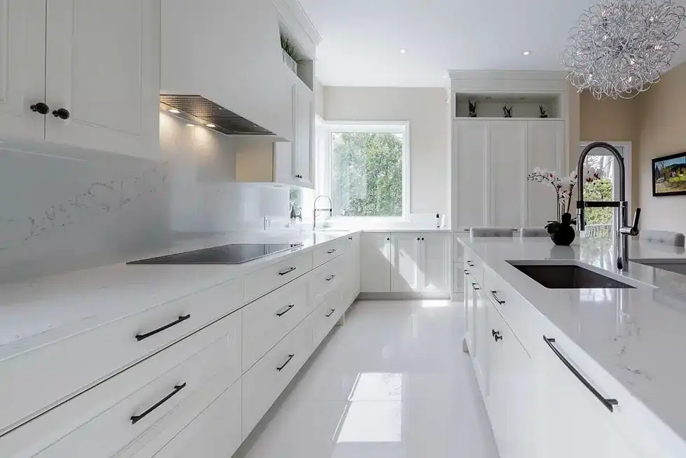 Bright modern kitchen with white cabinets, a large island, stainless steel fixtures, and a window with a garden view. Elegant chandelier above.