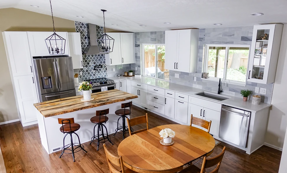 Bright kitchen with white cabinets, wood island, and bar stools. Stainless steel appliances, pendant lights, and a wooden dining table. Cozy mood.