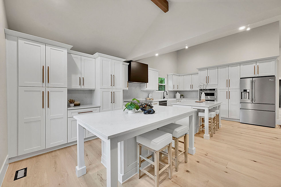Modern kitchen with white cabinets, marble countertops, and stainless steel appliances. Wooden floors and stools enhance the bright, airy space.