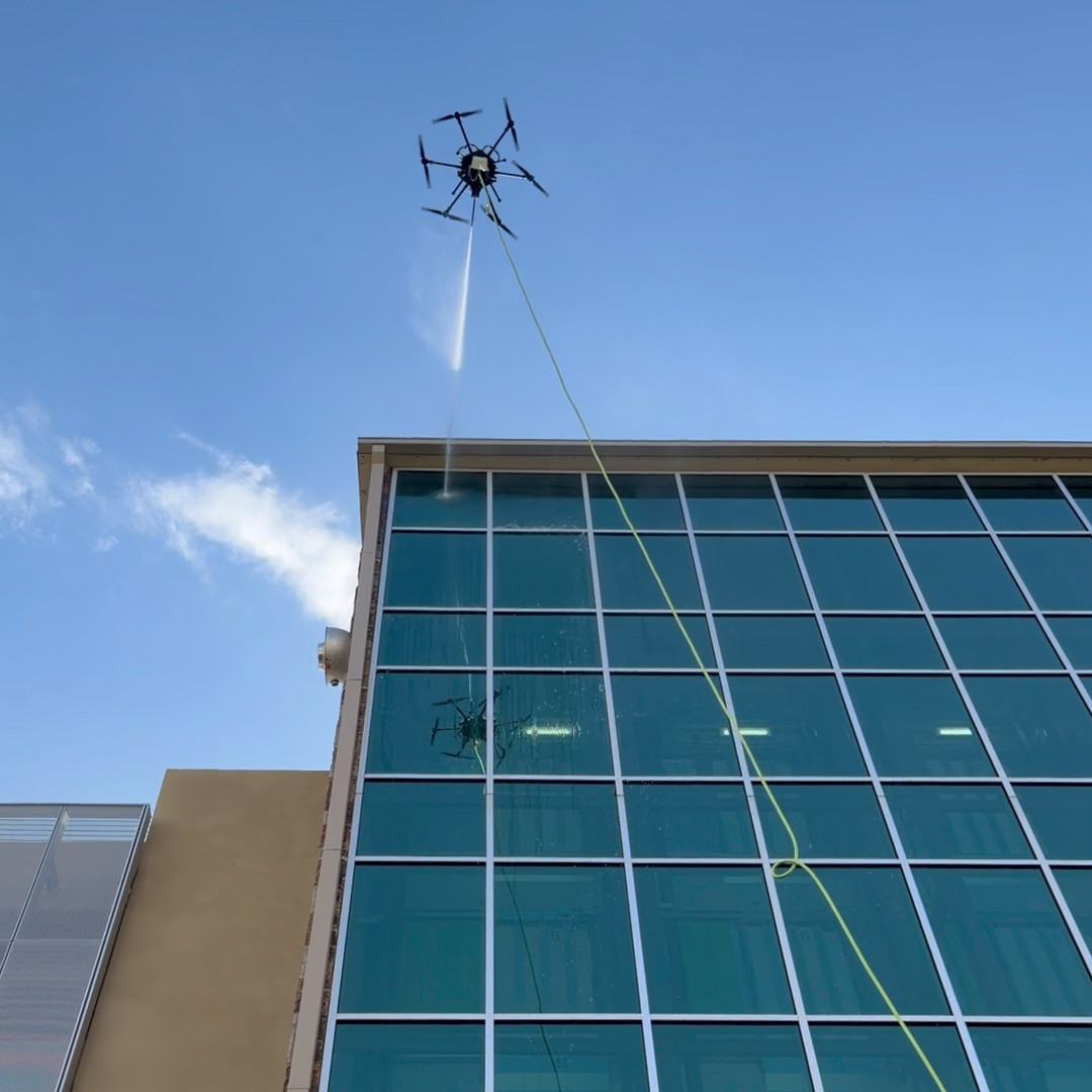 Drone cleaning 6 story glass curtain wall leaving pristine streak free glass behind.
