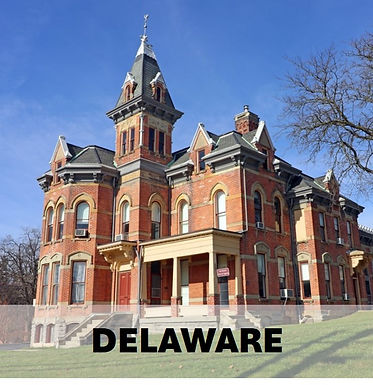 The historic Delaware County Courthouse in downtown Delaware Ohio under a blue sky.