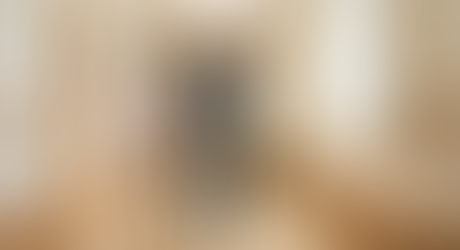 介護スタッフの見守りのもと、歩行訓練を行う高齢の男性。穏やかな施設内の廊下に差し込む日差しの中、前向きに一歩を踏み出している。