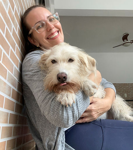 Dra. Mariana Poltosi sorrindo com um cão no colo