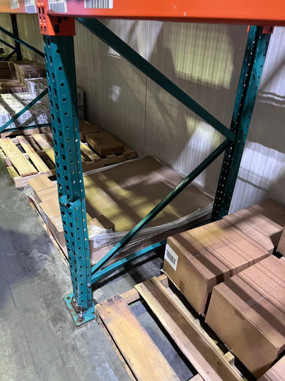Warehouse pallet rack with missing safety pin from horizontal beam connection, posing a structural safety hazard