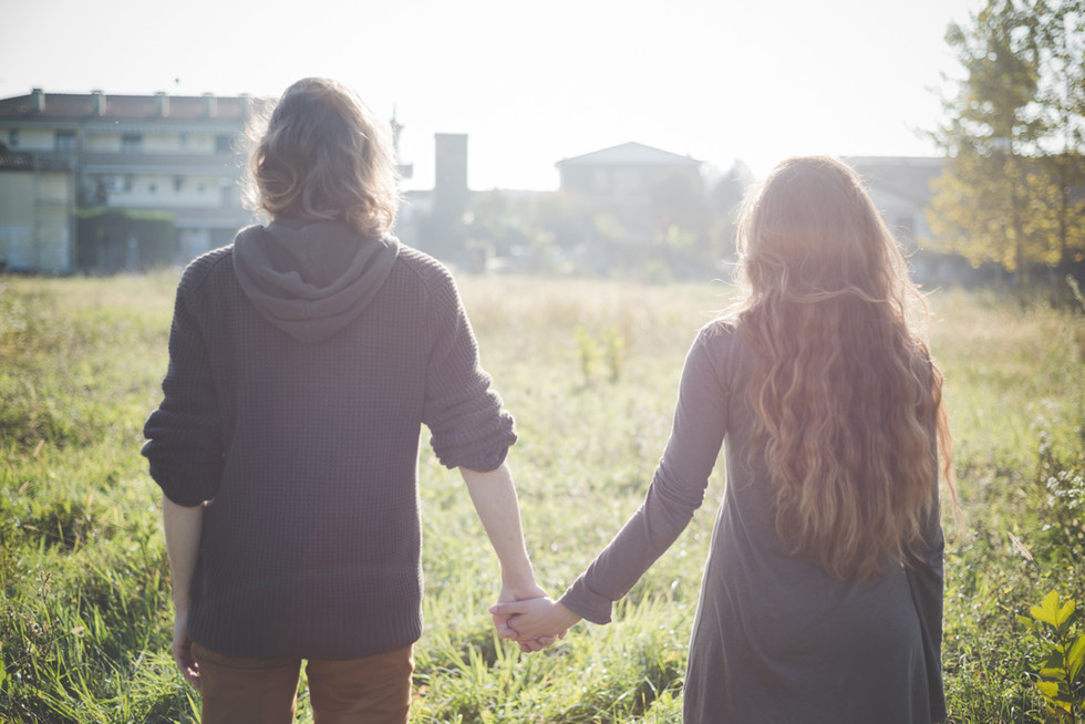a man and a woman holding hands in a field