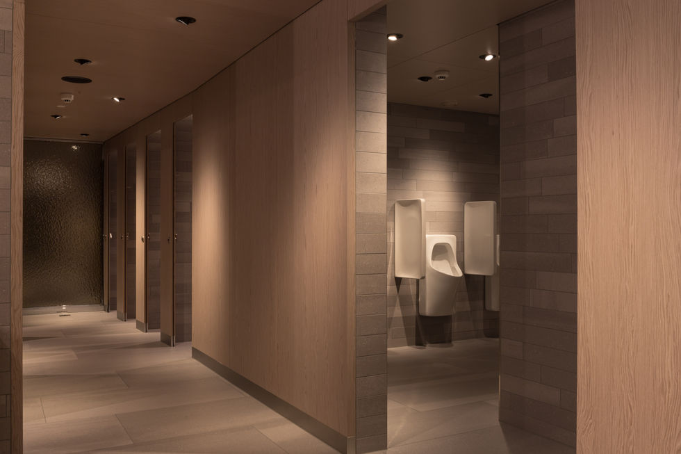 Blick in WC Korridor mit gedämpftem Licht und warmen Materialien