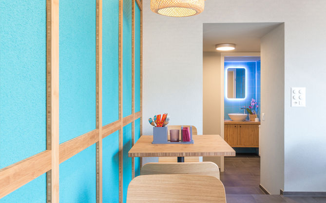 Blick durch den Gastraum bis zum Toiletten Bereich mit hinterleuchtetem Spiegel