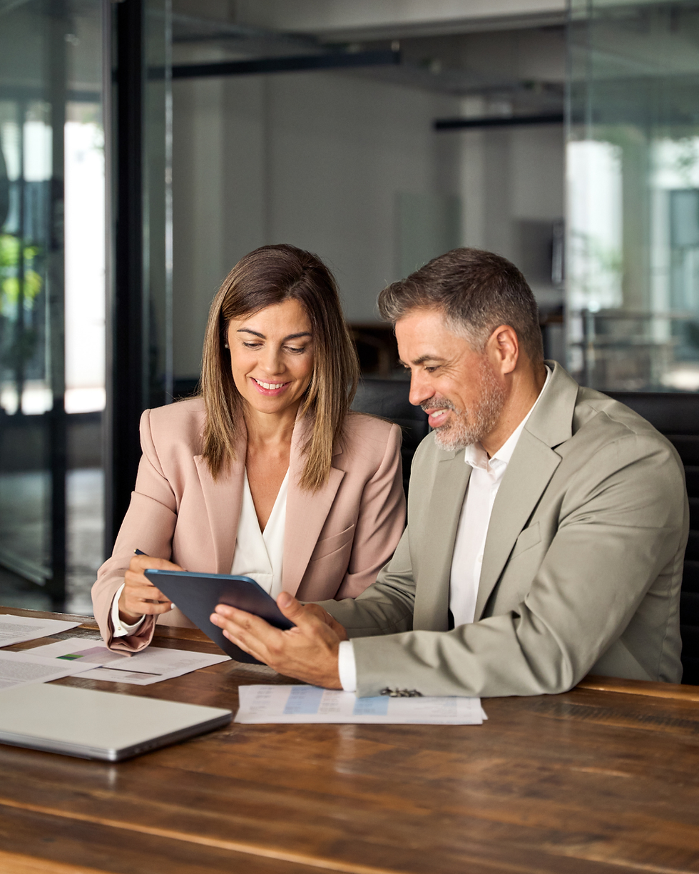 Professionals in a consultation reviewing data on a tablet
