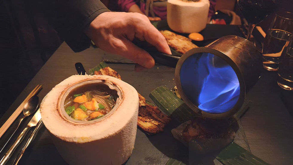 Mână de chef parizian dintr-un restaurant elegant aranjând preparate pe o tablă neagră