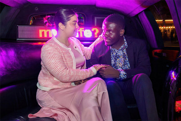 Couple amoureux dans une limousine avec panneau lumineux et regards complices