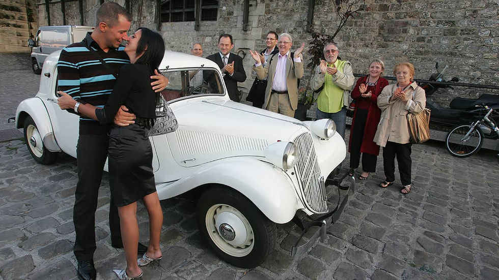 Deux amoureux s'embrassant devant une Citroën Traction blanche sur les quais de Seine à Paris