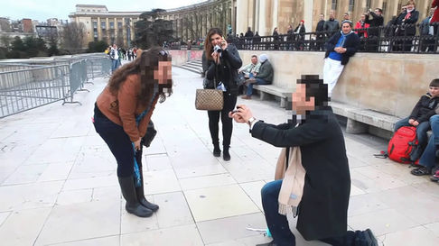 Femme surprise par la demande en mariage d'un homme, genou à terre sur le parvis du Trocadéro à Paris