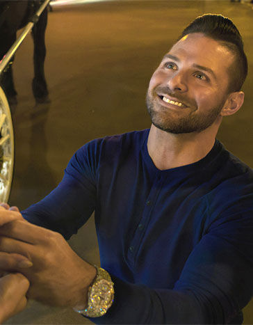 Un homme s'agenouille et tient la main de sa bien-aimée lors d'une demande en mariage en soirée à Paris